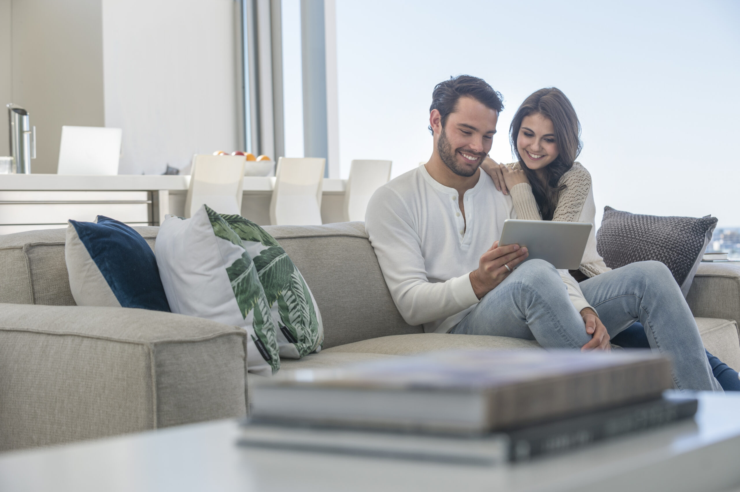 Casal sorrindo enquanto realiza a compra segura de um apartamento na planta.